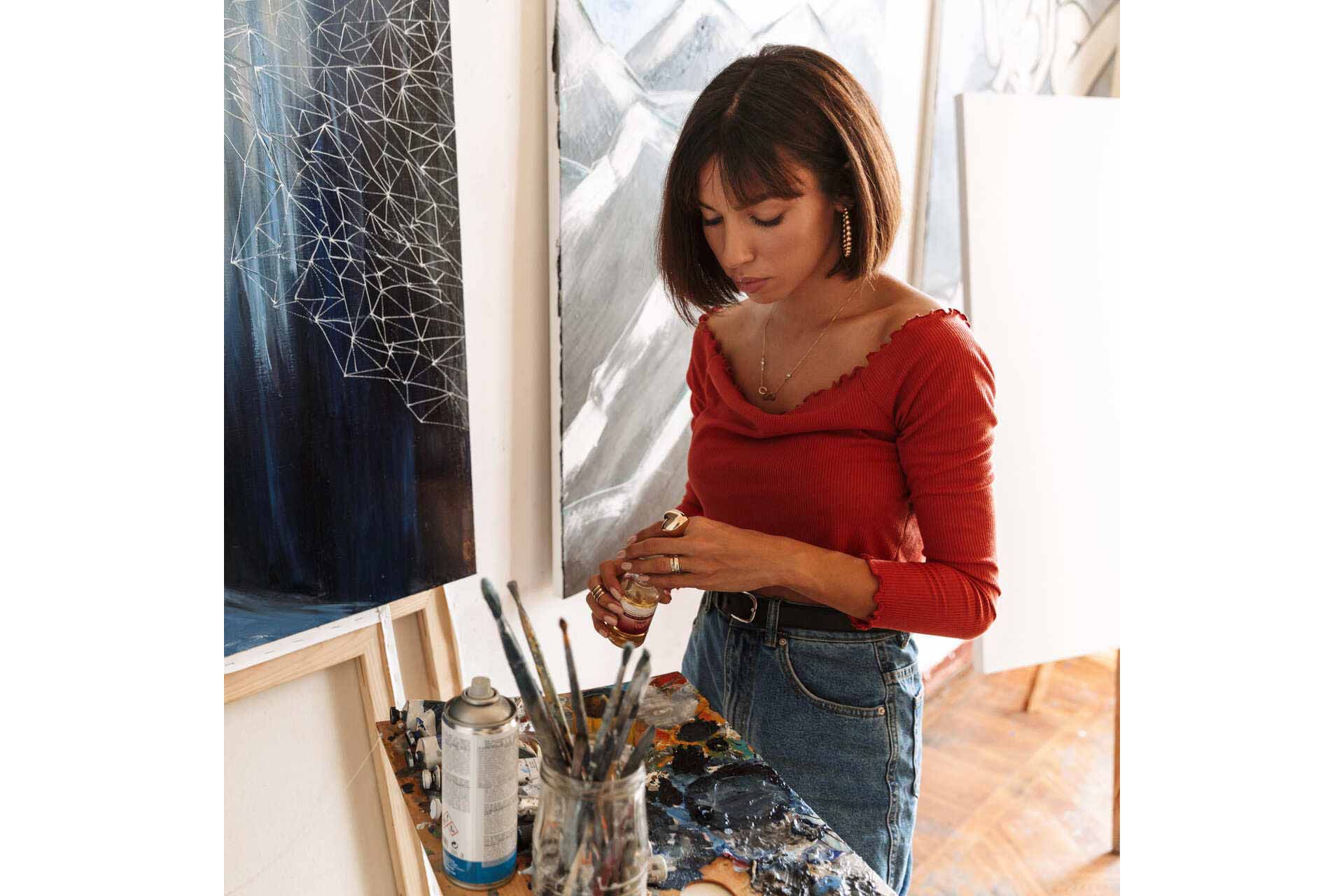 1-portrait-of-young-woman-using-painting-tools-while-2GVZ4TB.jpg